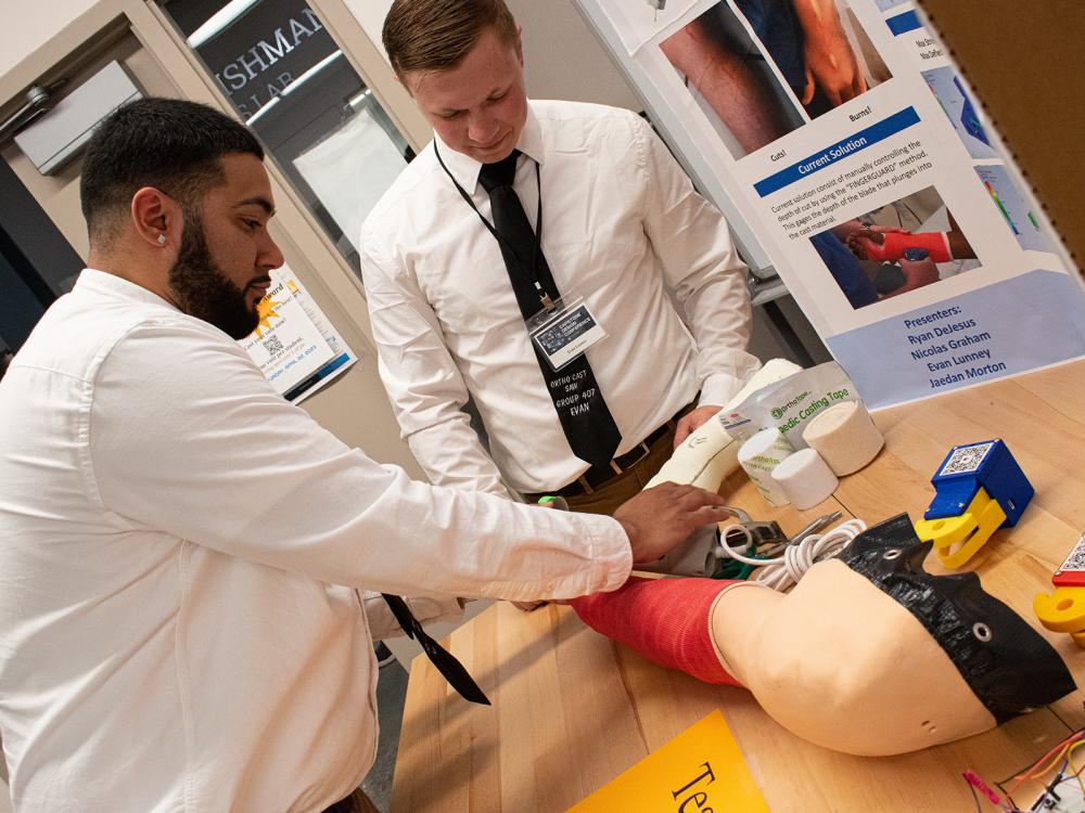 two male students demonstrating a cast removal project