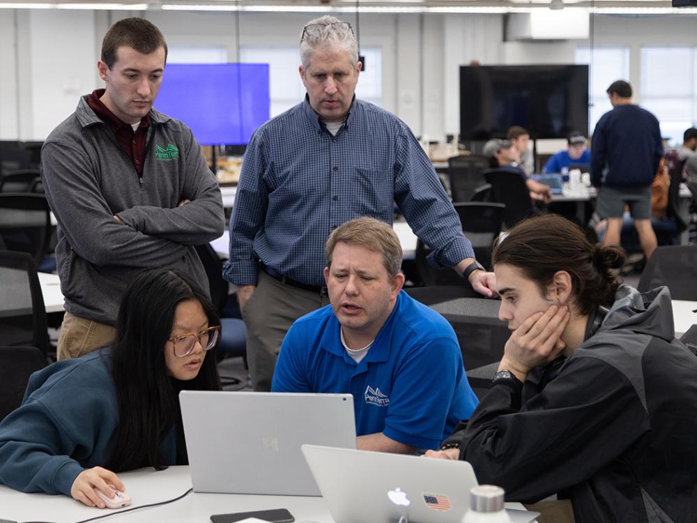 Evan Heiser, Jon Houser, and David Goldberg speak to students Beiqi Feng and Jacob Weisberg.