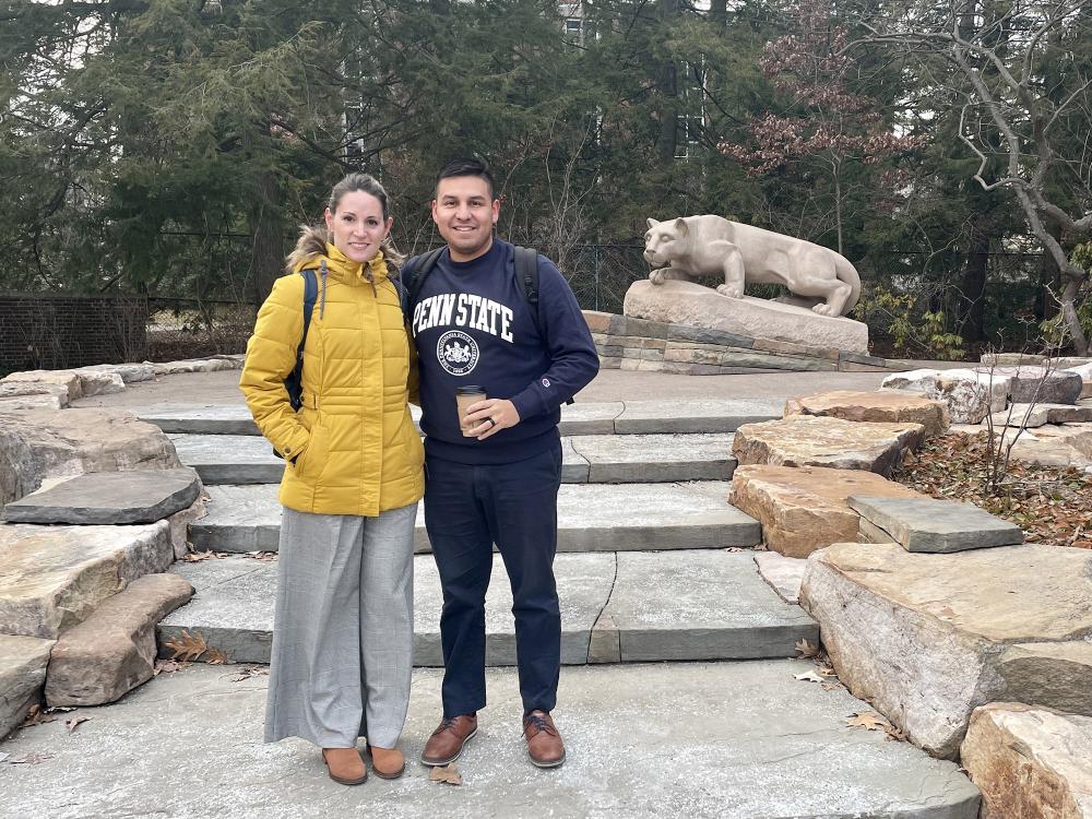 Marian Viera Fuentes and Sylvester Fernandez de Castro stand with the Nittany Lion shrine statue in the background.