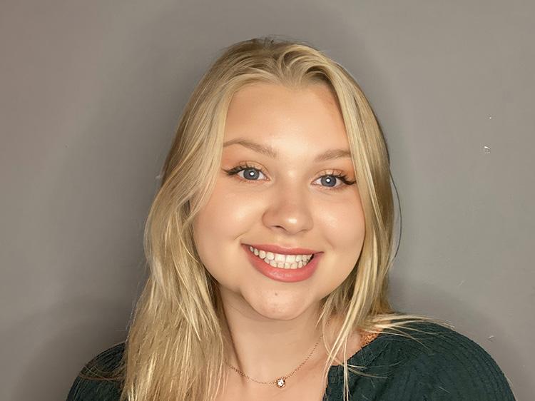 Smiling blond haired girl in a dark shirt