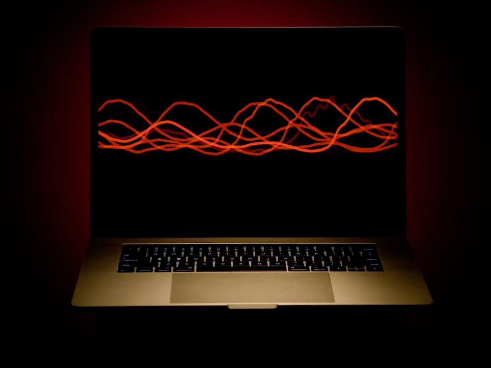 A laptop computer with a blank screen interrupted across the middle by wavy red lines