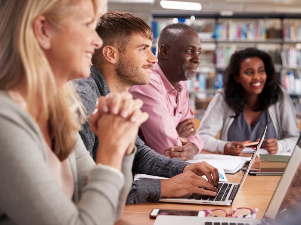 Four diverse adults students attending a class
