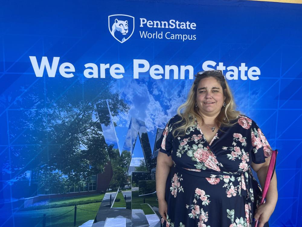 Female student in front of "We Are Penn State" screen