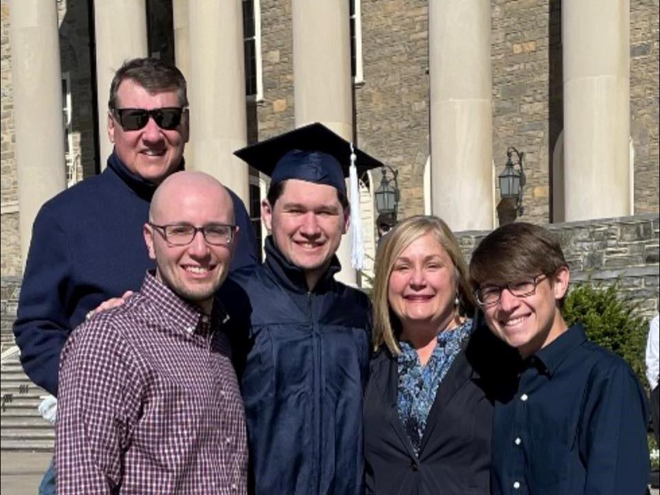 Bob '87 and Terese Martin stand on the steps of Old Main with their sons, Daniel, John, and Samuel.