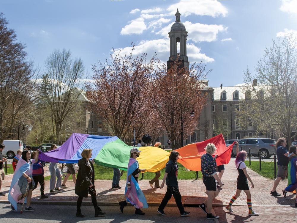 Students and staff march past Old Main during the Pride March in 2023