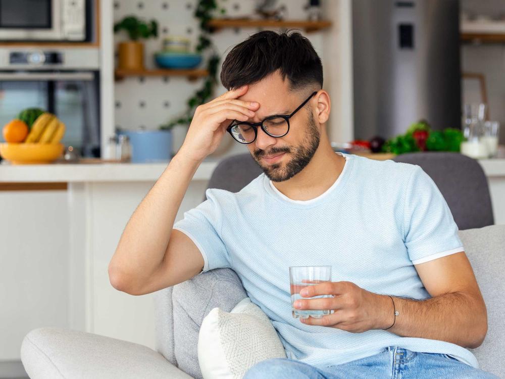 man with a headache holding hand on his head