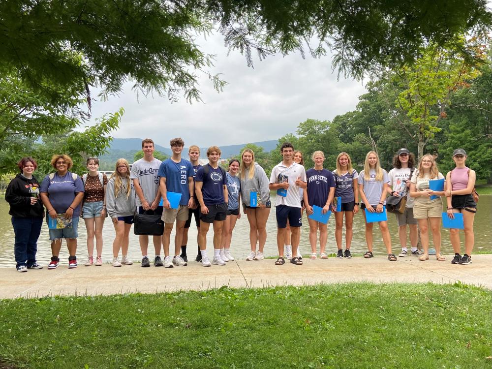 High school students standing lakeside for a group photo