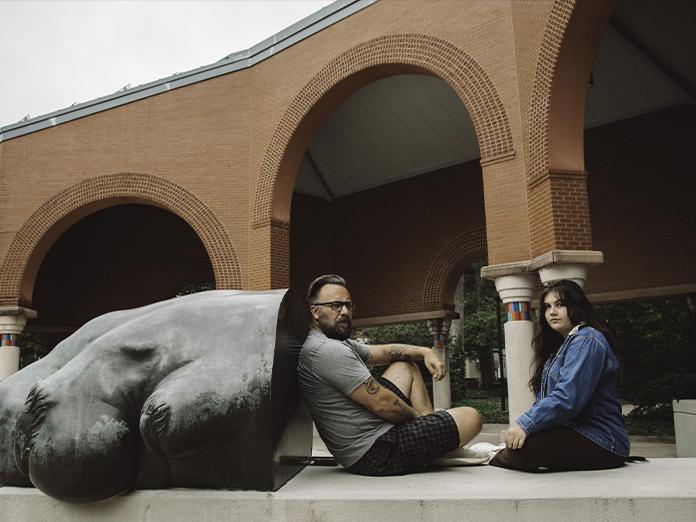 young woman and man sit side by side on penn state campus