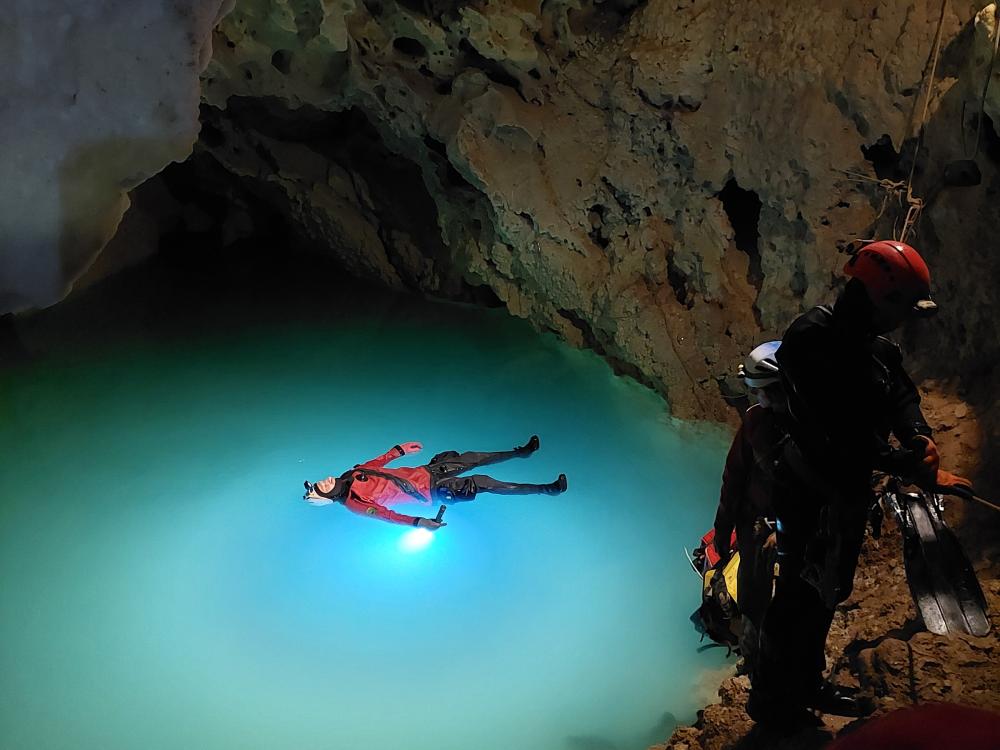 A cave diver floating in an underground lake
