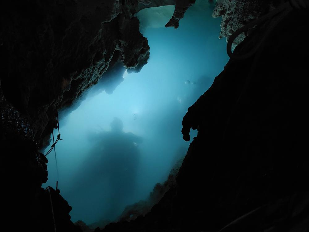 Shadows of divers seen through an underwater cave