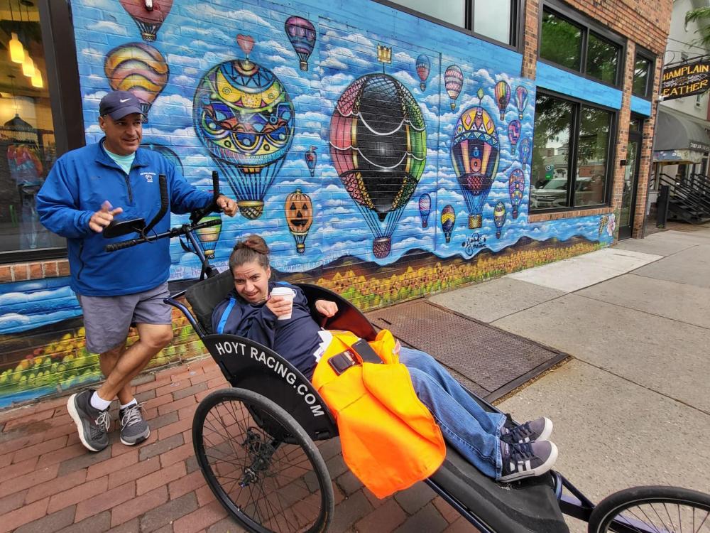 Dan and Emma Perritano pose in front of a mural in Vermont.