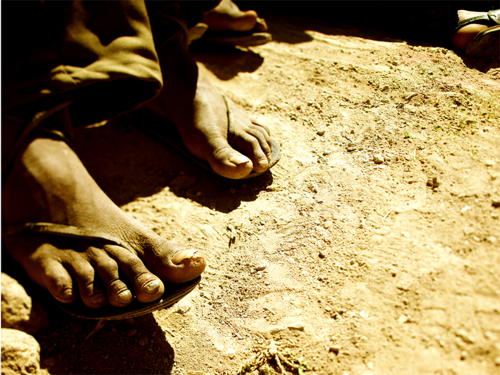 Indigenous children's' feet standing in dirt