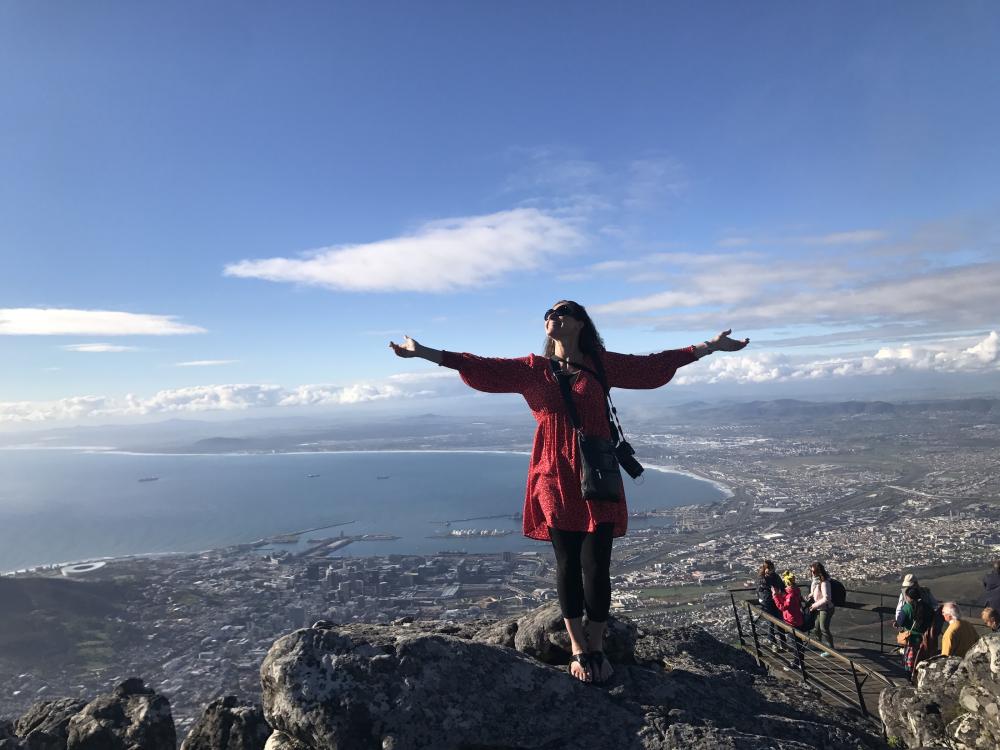 Woman standing on mountaintop vista with arms outstretched