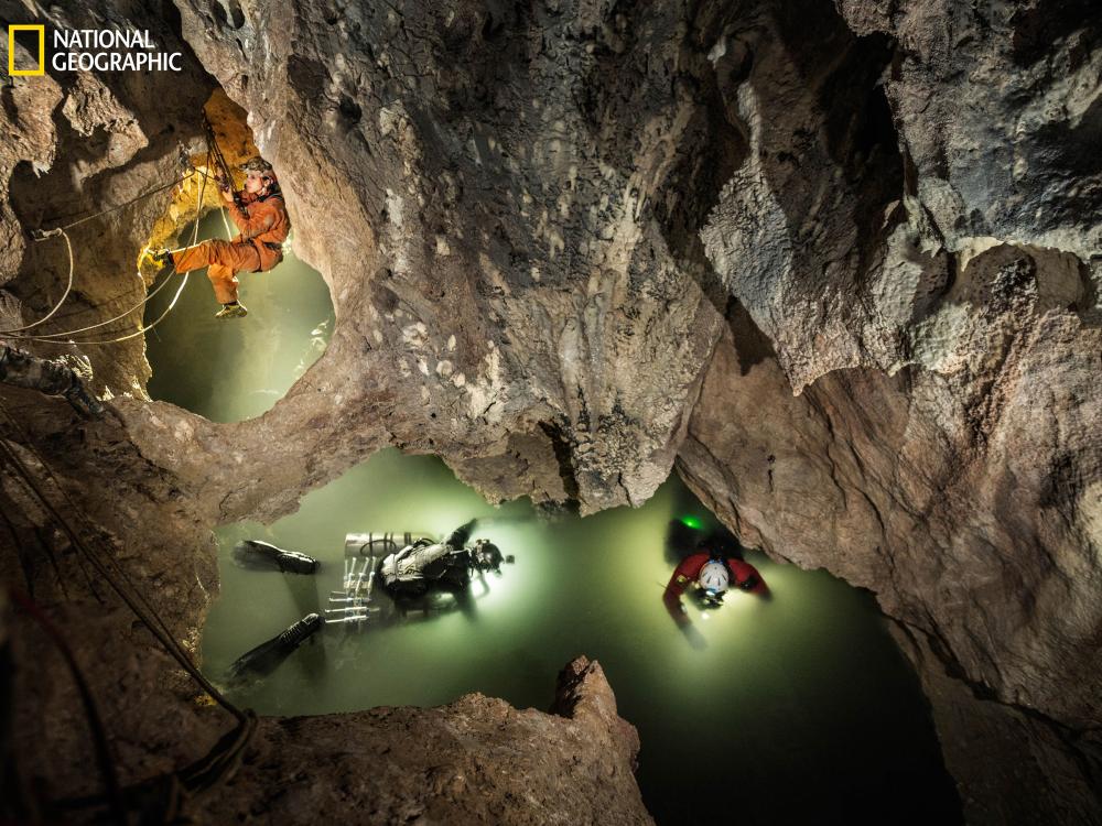 Cave divers float in an underground lake