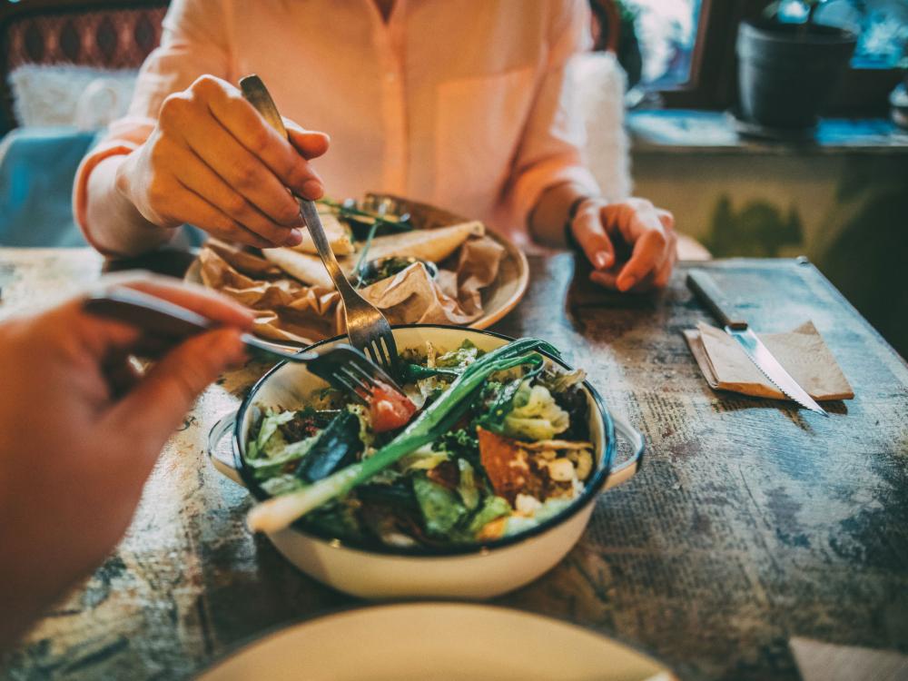 a point-of-view image of a restaurant table with two salads