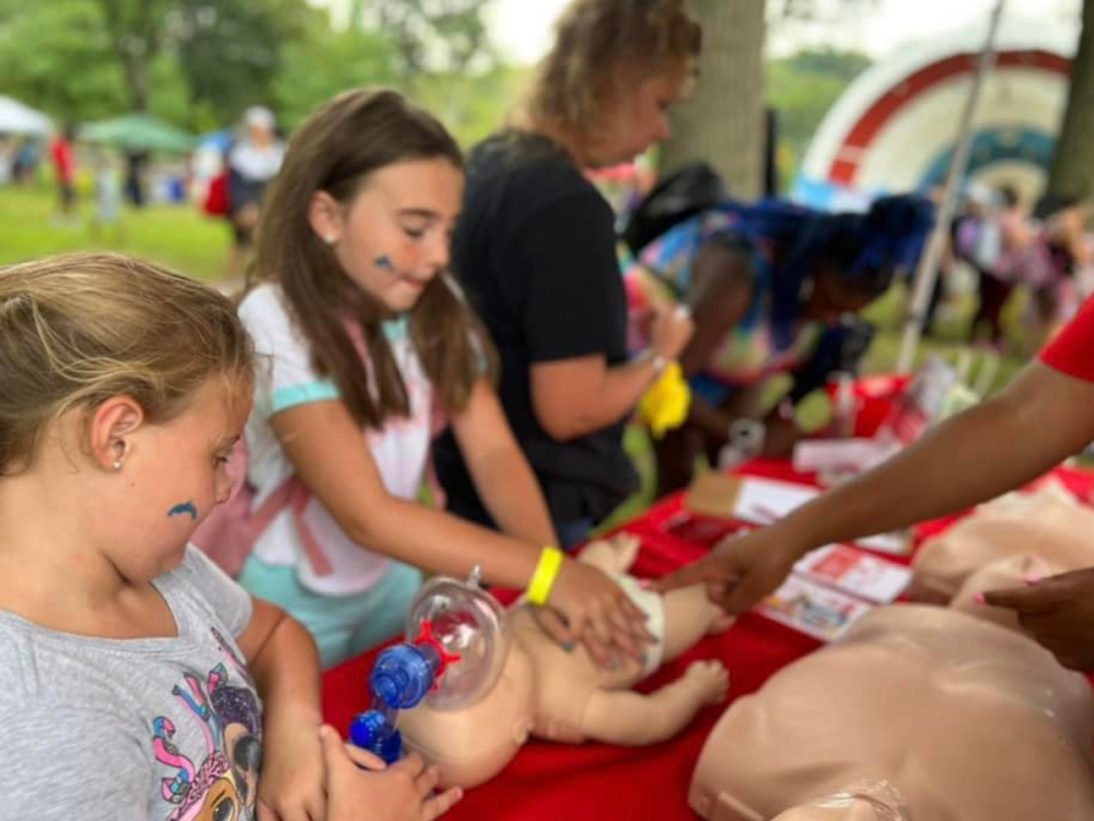 Children practicing CPR on a baby doll