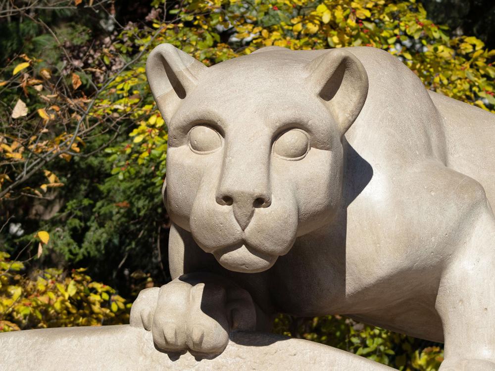 The Nittany Lion Shrine with fall foliage in the background.