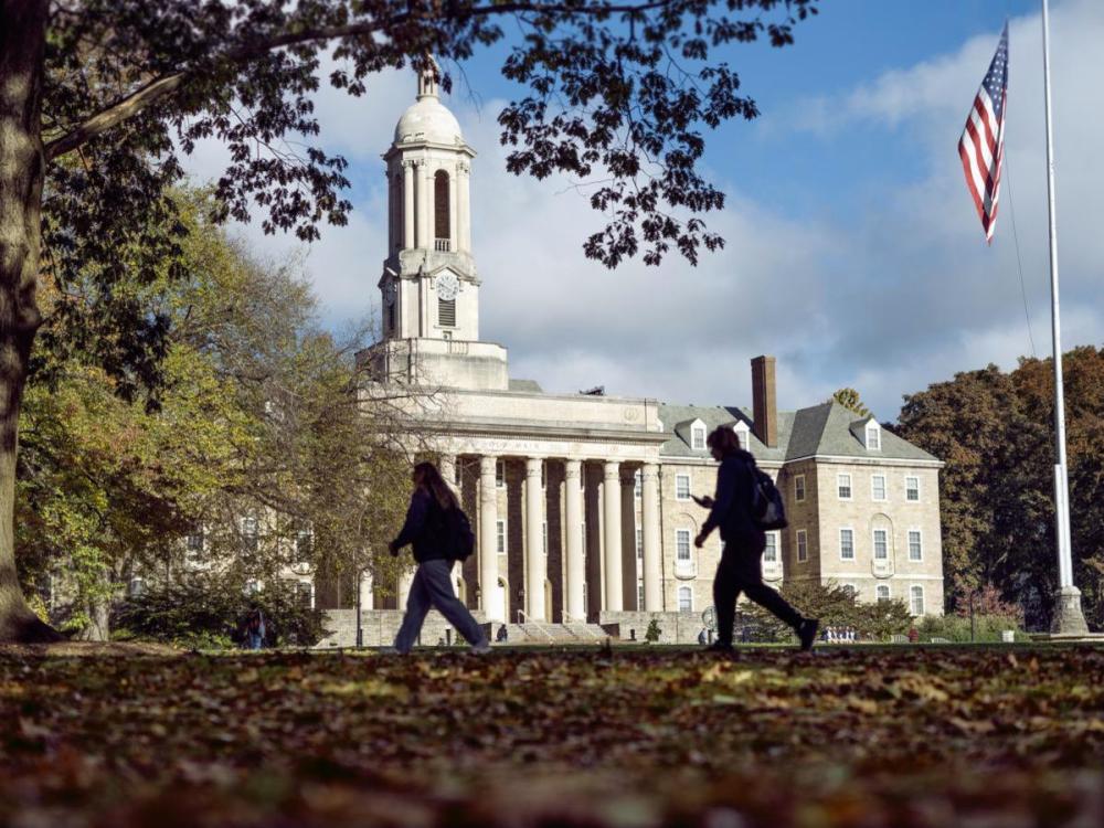 Old Main in background as people walk by in foreground