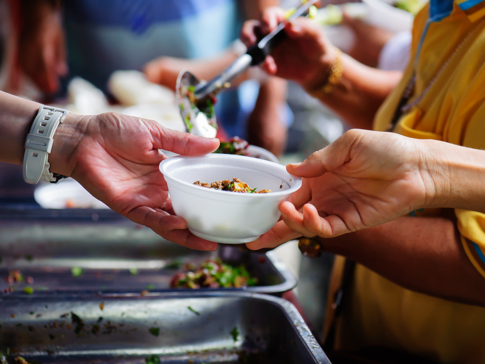 A person handing another person a bowl of food