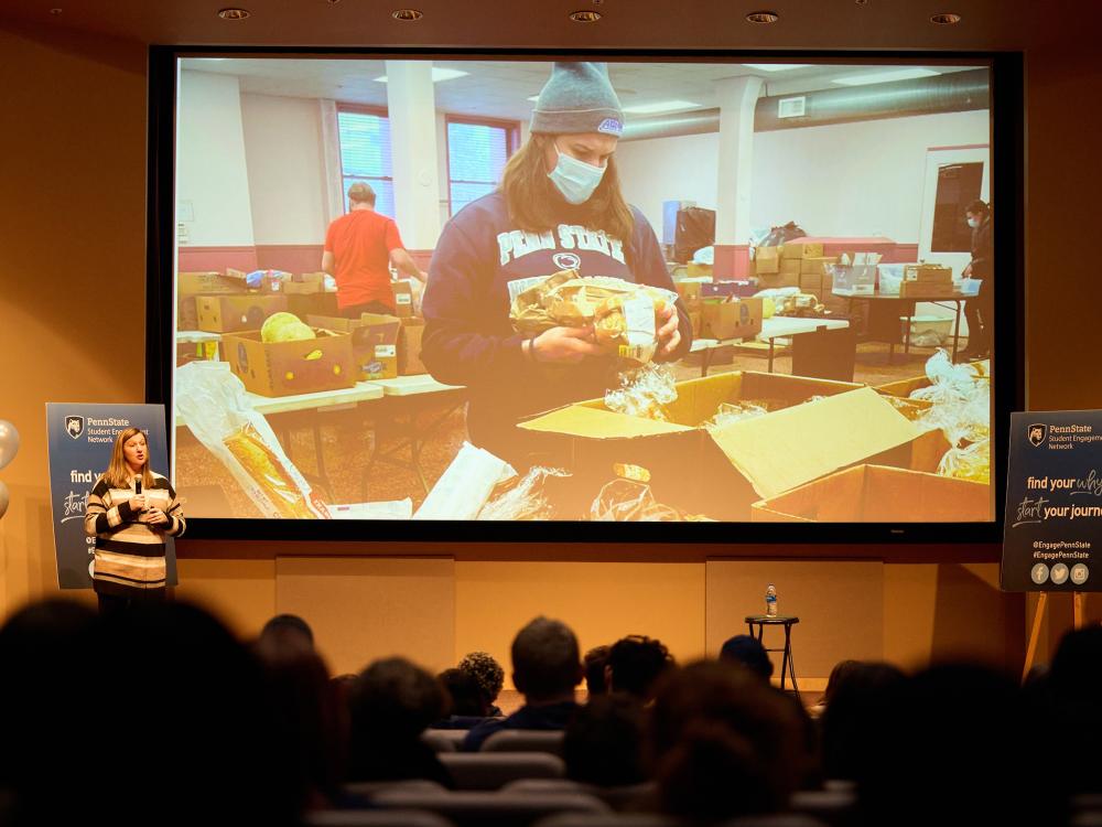 Woman presenting to audience in front of projection screen
