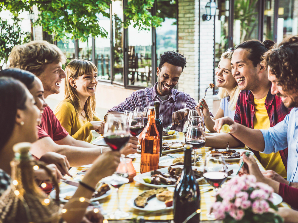 Group of people sitting around a table and eating together