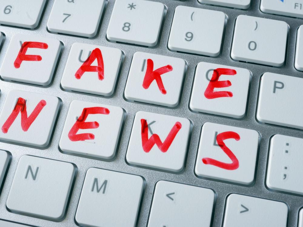 computer keyboard with fake news written in red marker