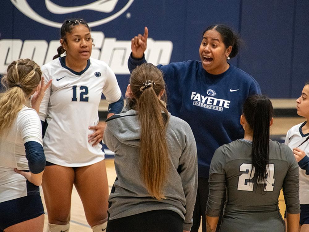 Women's volleyball players listening to their coach.