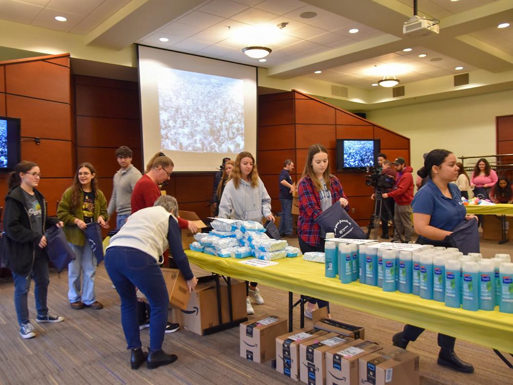 Students, faculty, and staff assembling hygiene kits for the YWCA of York