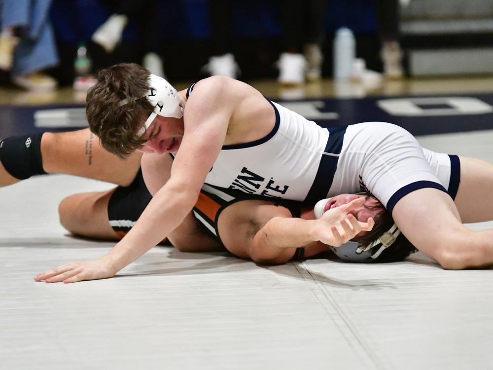 A Penn State Behrend wrestler pins his opponent.