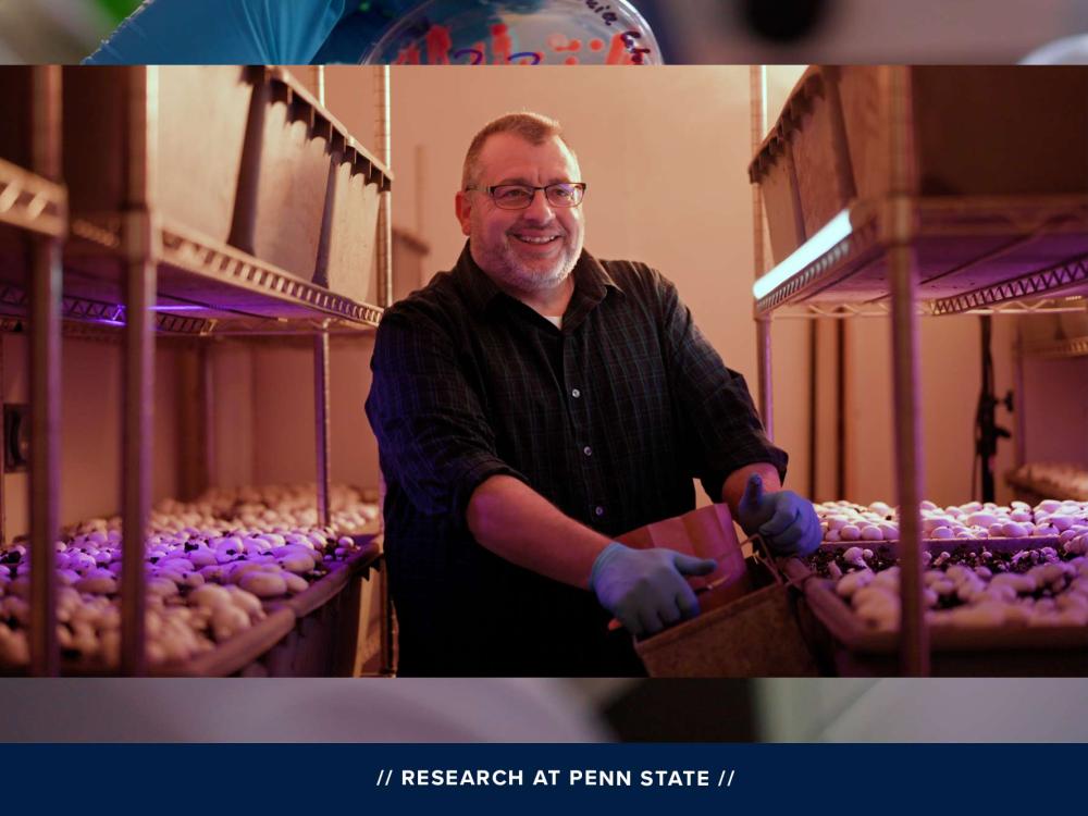 John Pecchia holding a tub of mushroom compost and smiling