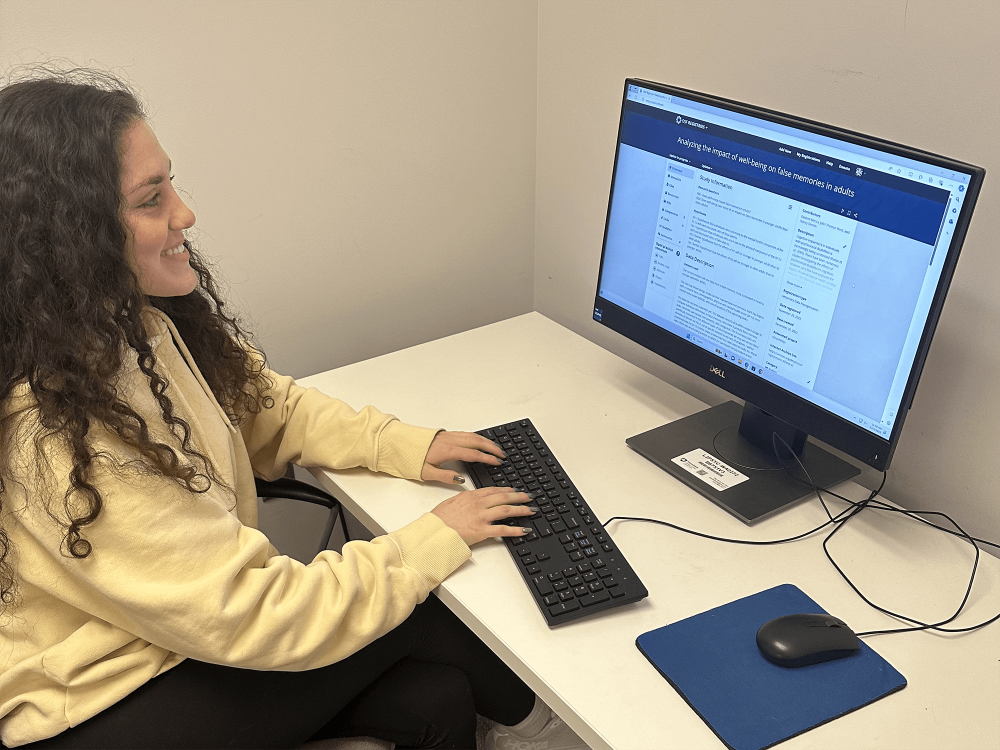 Desirée Mecca, a fourth-year psychology student, sits in front of a computer monitor while submitting preregistration information for her independent project.