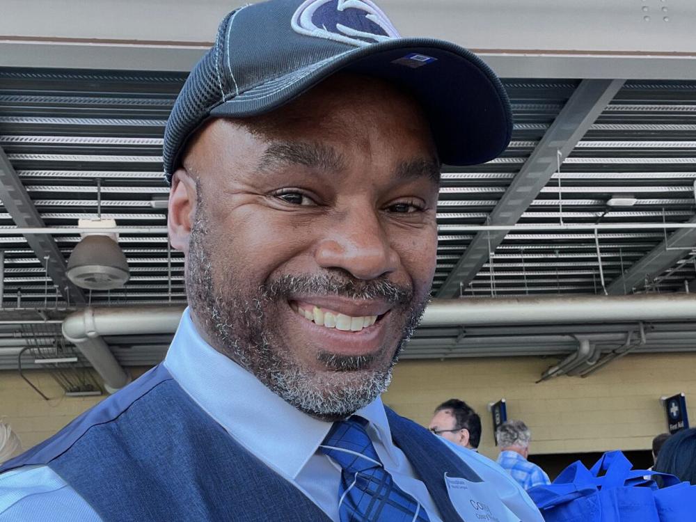 smiling person wearing baseball cap