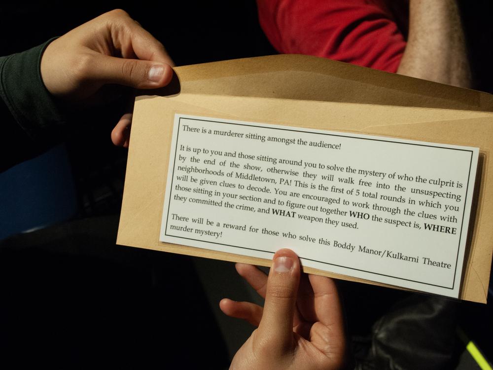 Closeup of an envelope with instructions for solving a mystery during a performance of "Clue"