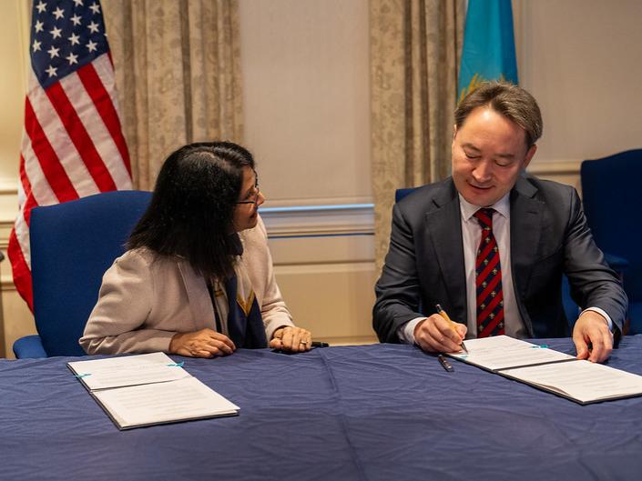 A man and a woman at a table, signing documents