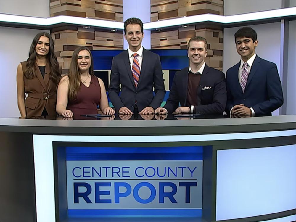 Five students at TV newscast desk