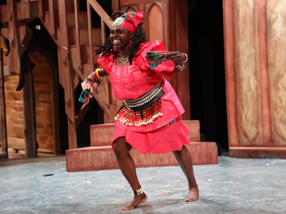 African American woman wearing West African clothing as she dances