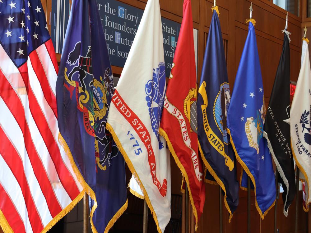 A line of of the American flag and flags of the U.S. Armed Forces.