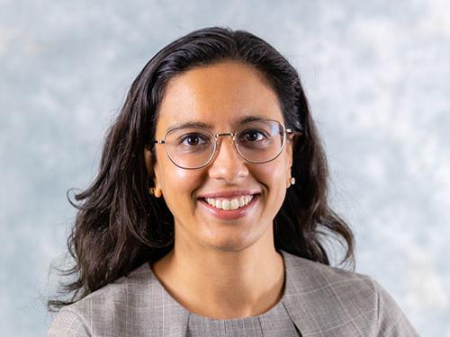 smiling person with long dark hair and glasses