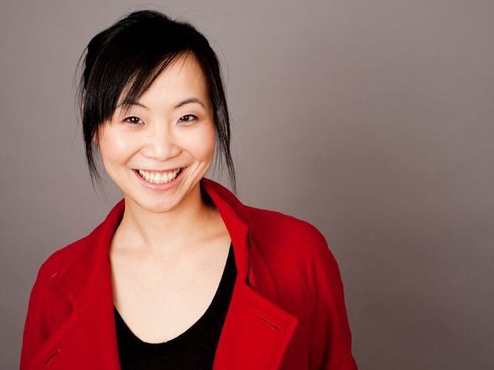 Head shot Asian woman with dark hair wearing a red sweater and smiling 