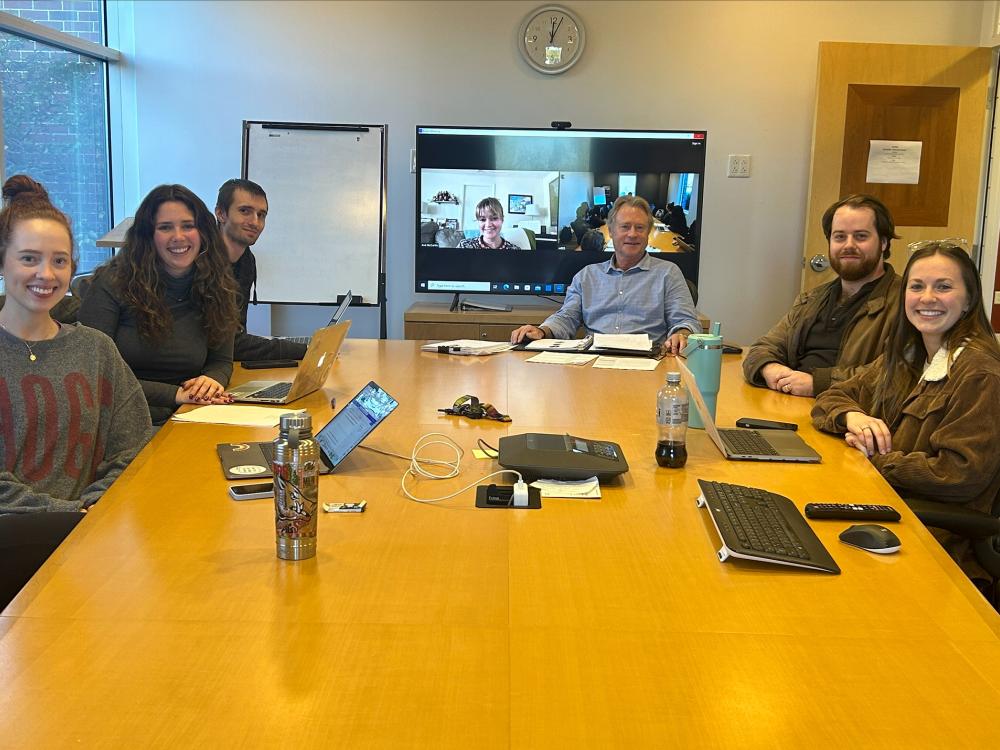 A group of people sit around a conference table for a meeting.