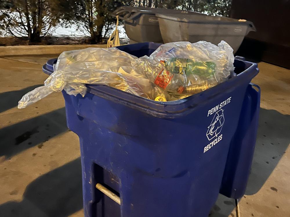 Blue recycling bin full of recycled materials.