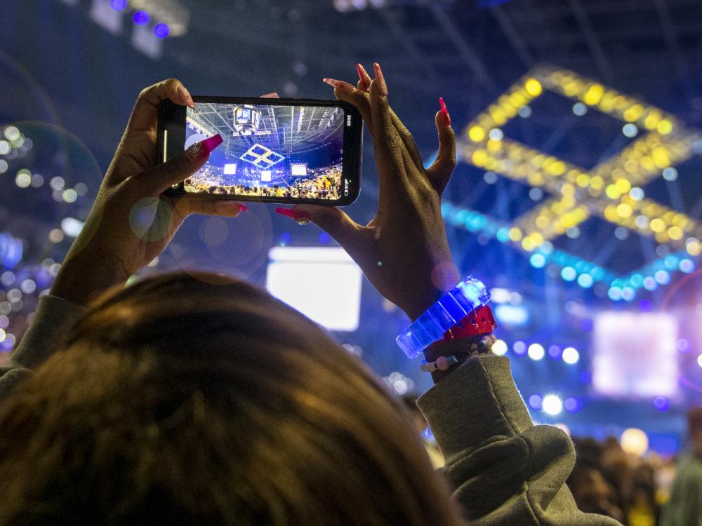 An individual at THON uses a smartphone to take a picture of the four diamonds on the ceiling