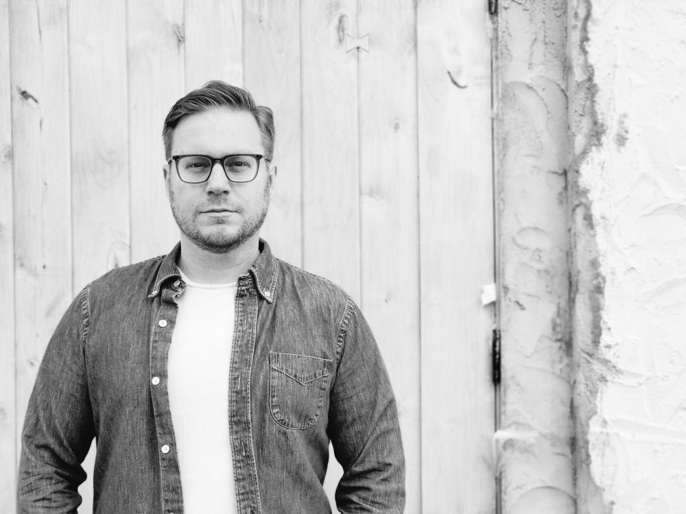 Black and white photo of a person wearing glasses.