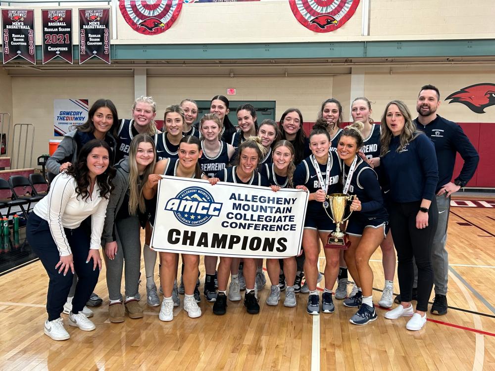 The Penn State Behrend women's basketball team holds the AMCC championship banner.