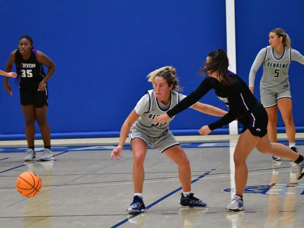 A Penn State Behrend basketball player scrambles for the ball.