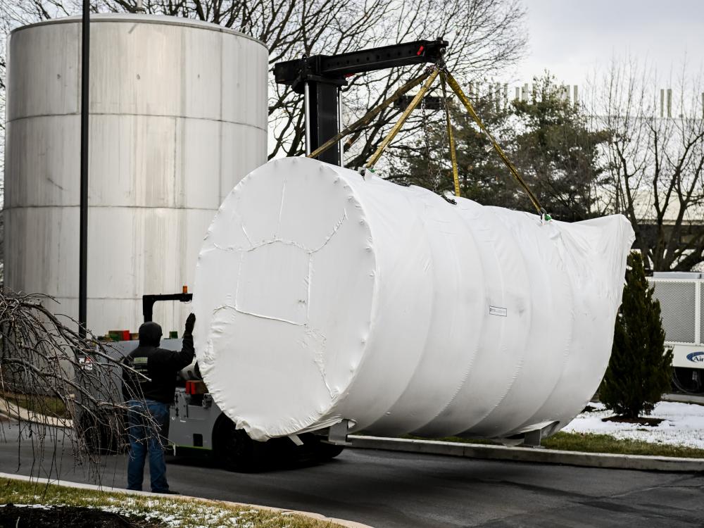 a large cylinder container being moved by a lift