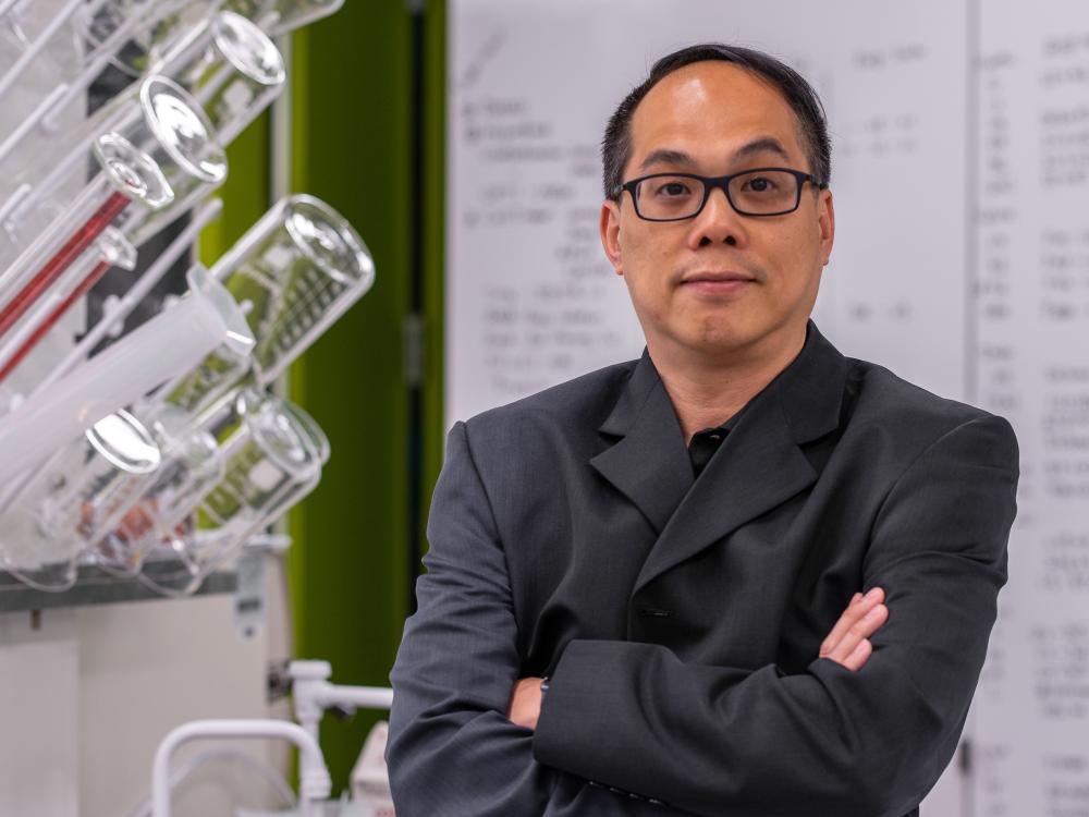 A posed portrait of a person wearing glasses in a lab setting