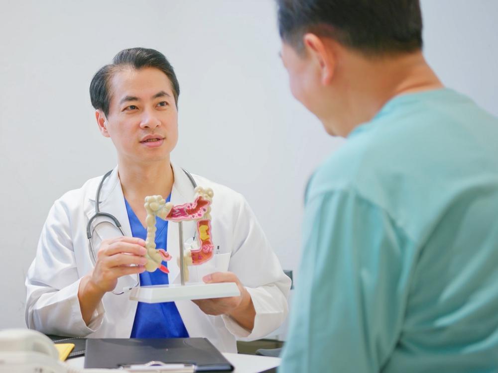 A doctor explains a colonoscopy result to a patient.