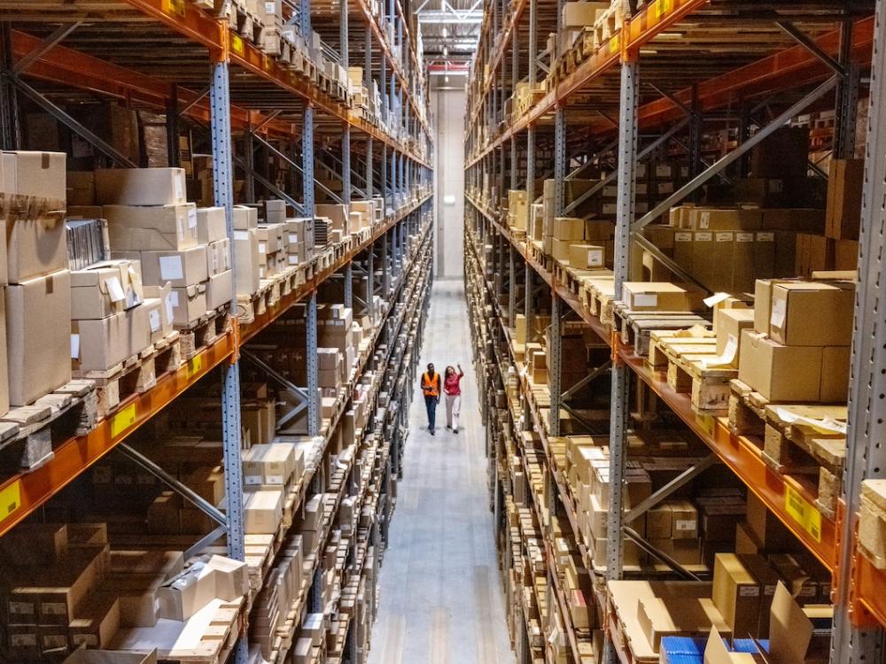 Two people walking through warehouse. 
