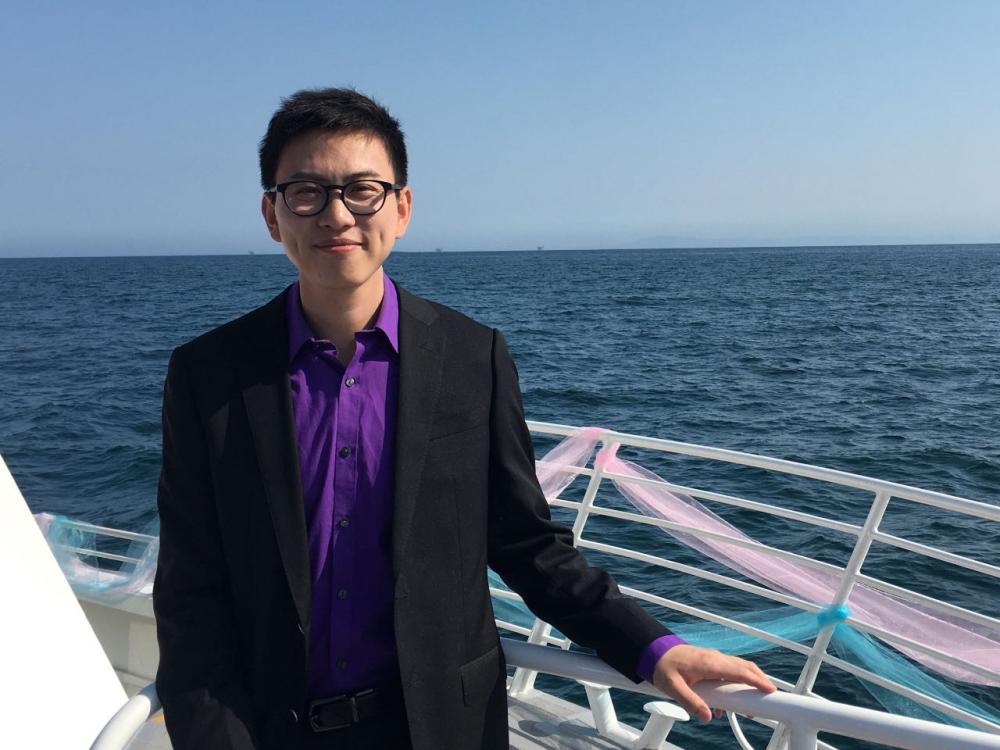 Zhen Bi stands on dock with ocean behind